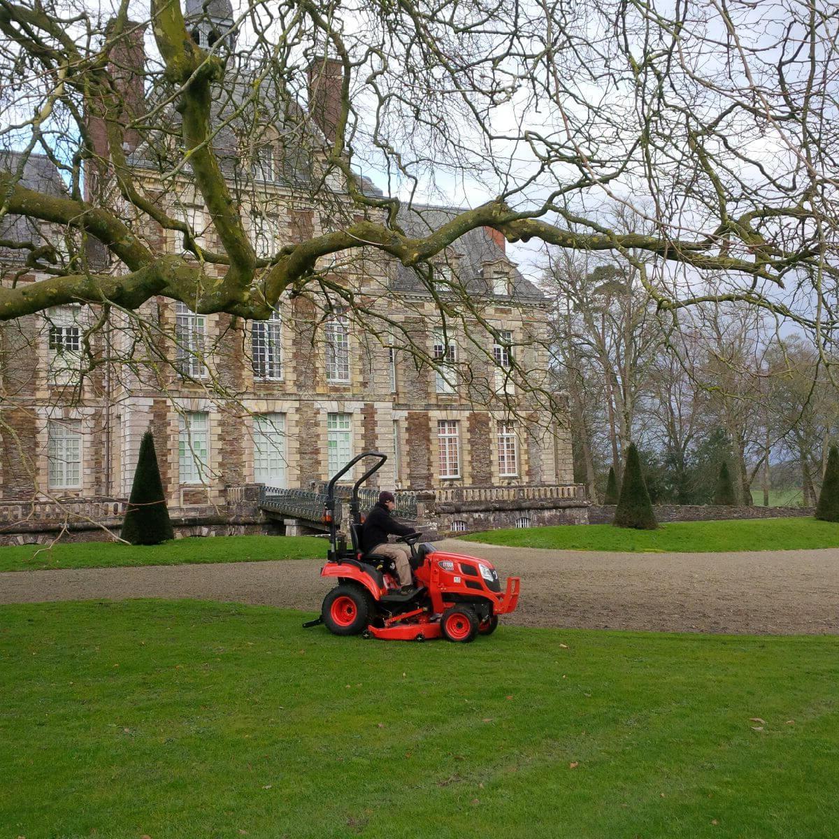 A Kioti tractor for garden maintenance in front of a big house